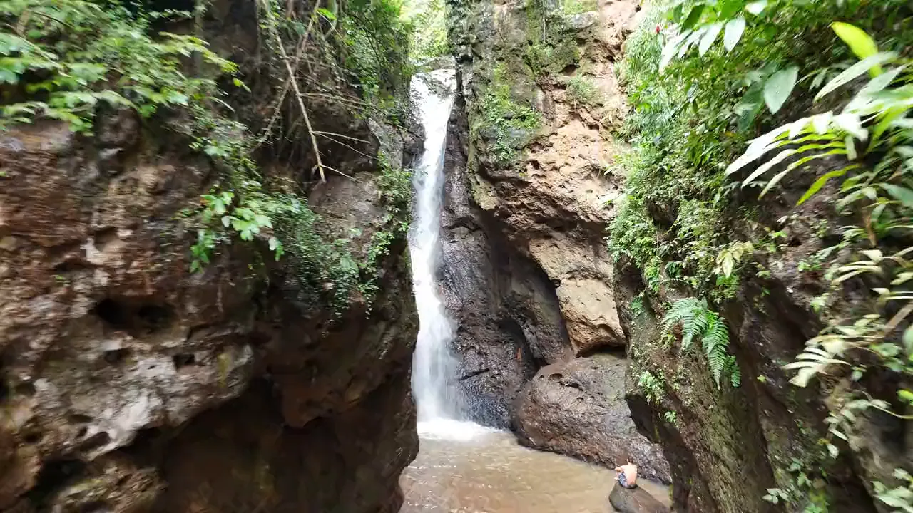 Pam Bok Waterfall dropping into the gorge between rock walls hung with ferns