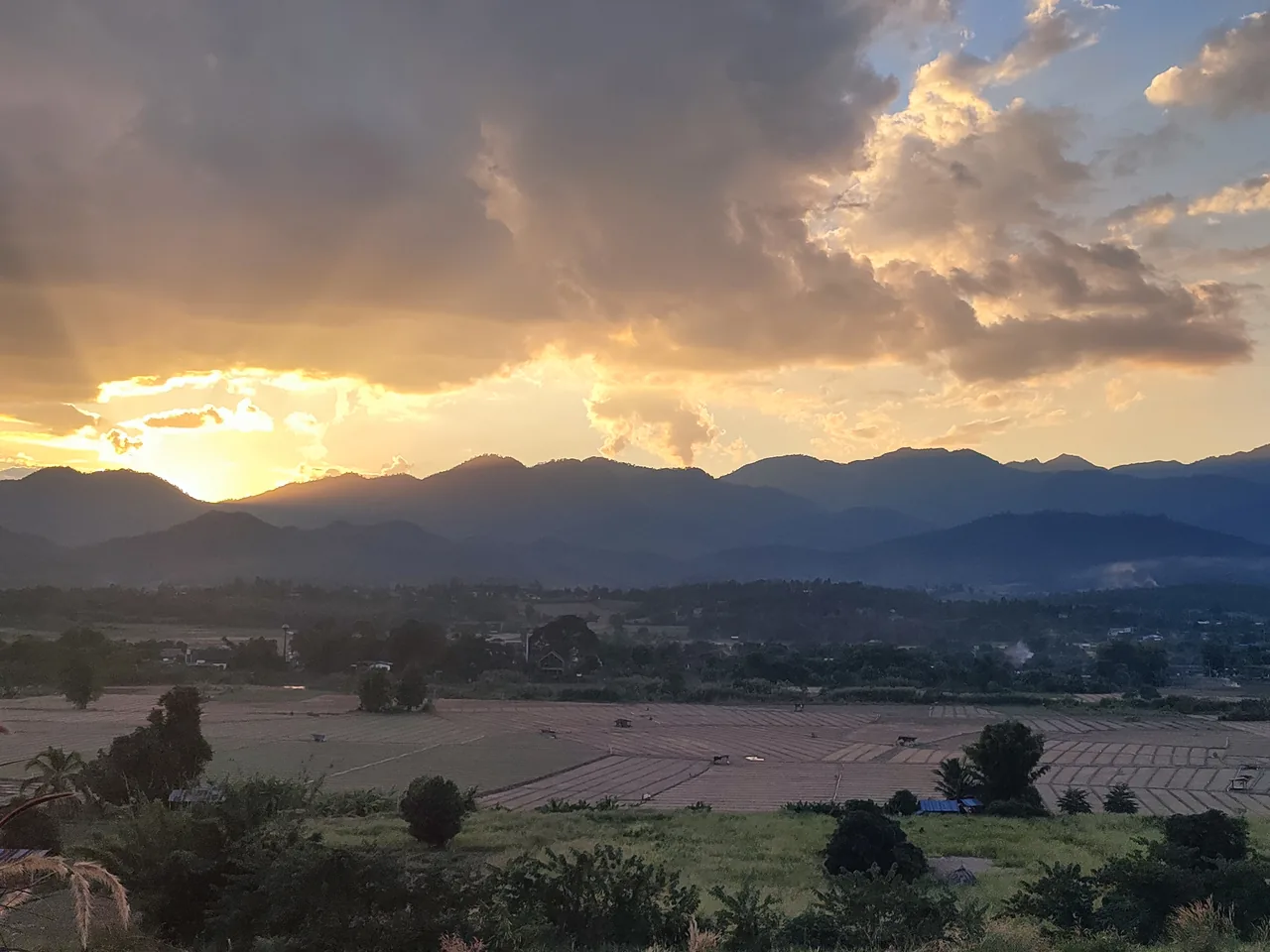 The sun going down behind the mountains in November, seen from Two Huts, with the valley’s fields in pale strips below