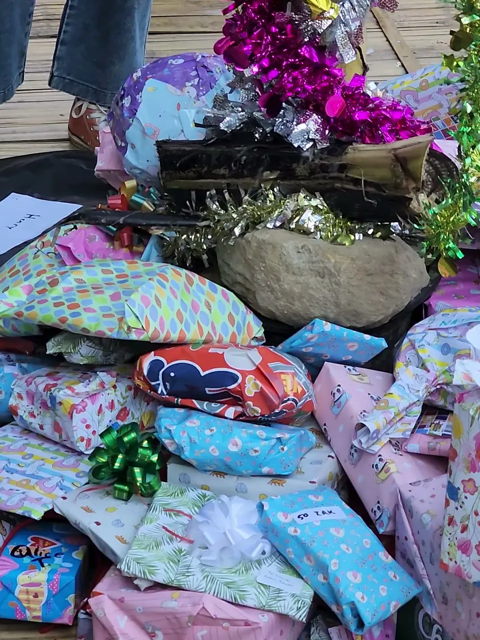 Secret Santa presents in bright wrapping paper piled at the foot of the tinsel-wrapped banana tree at Nolo Hub Pai on Christmas morning