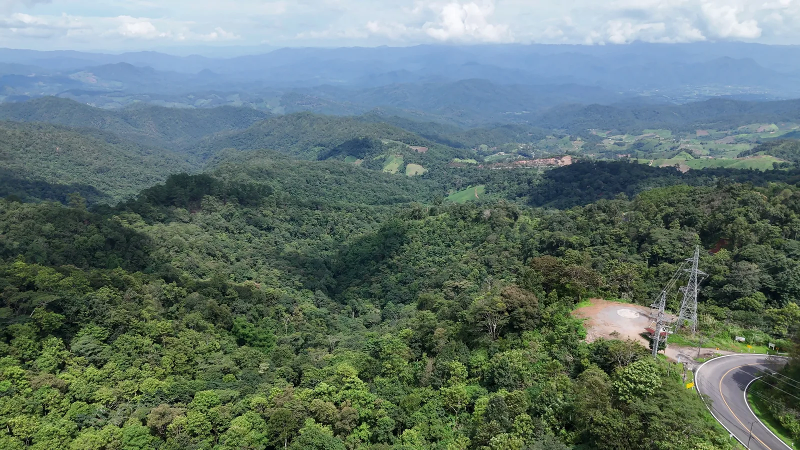 The mountain road curving through the forest below Doi Kiew Lom