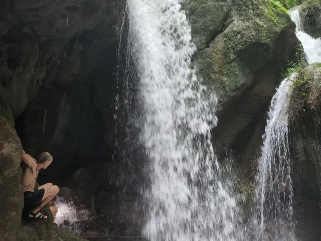 Hua Chang Waterfall pouring into its pool between dark rock walls