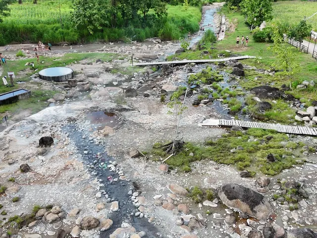 The hot spring field at Muang Paeng: mineral-crusted rock, the stream and the round pool