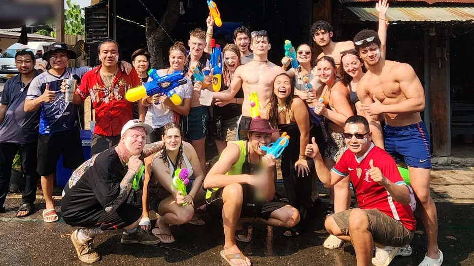 A Nolo Hub group and friends in the street, white powder on their faces, holding up water guns and giving thumbs up