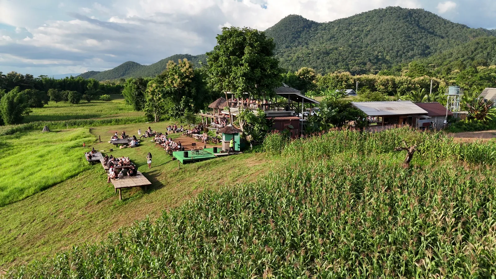 Tables on the grassy slope at Two Huts, with the mountains behind